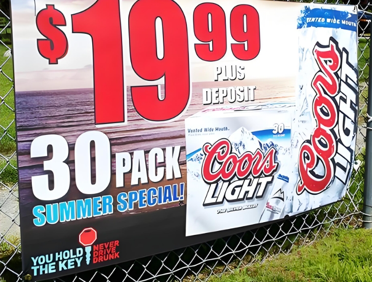 Large promotional poster on an outdoor fence